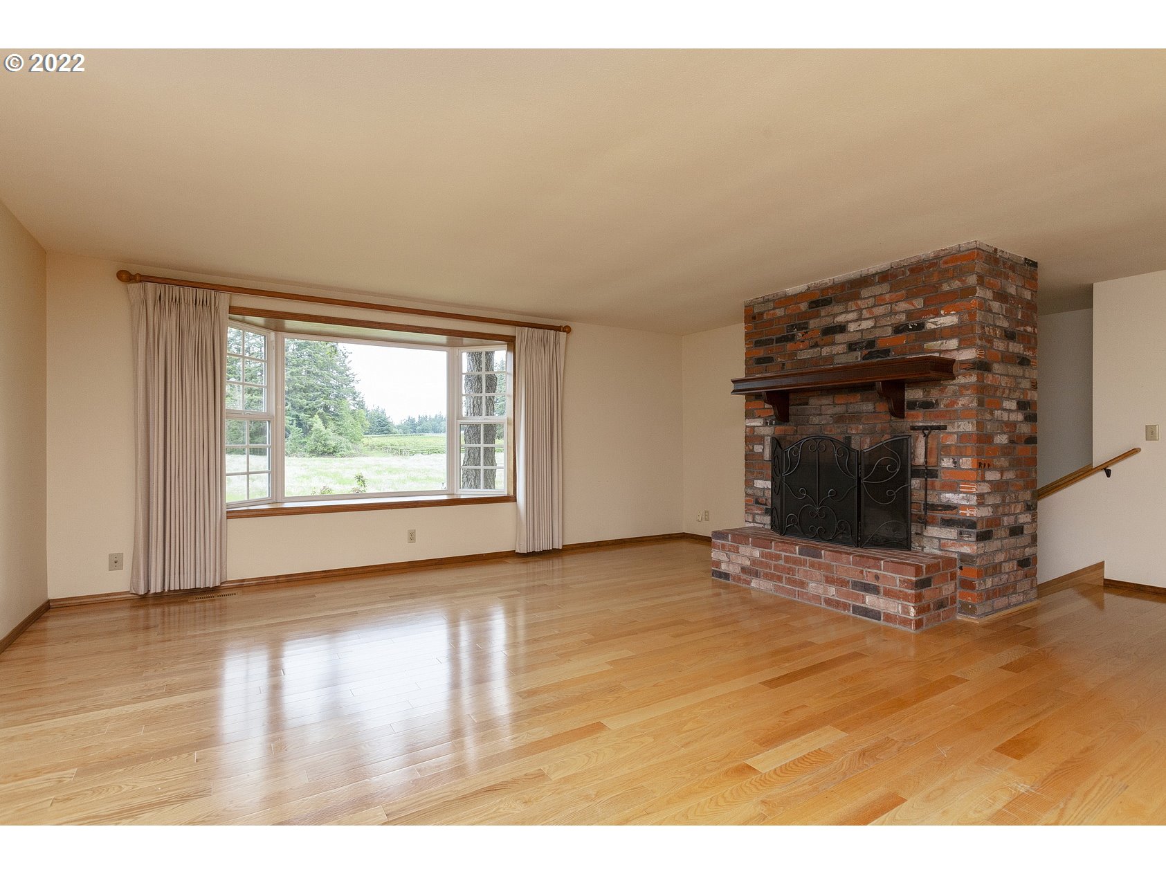 16190 South Wilson Road Oregon City, OR 97045 - Photo 7 of 32 a view of an empty room with wooden floor and a fireplace
