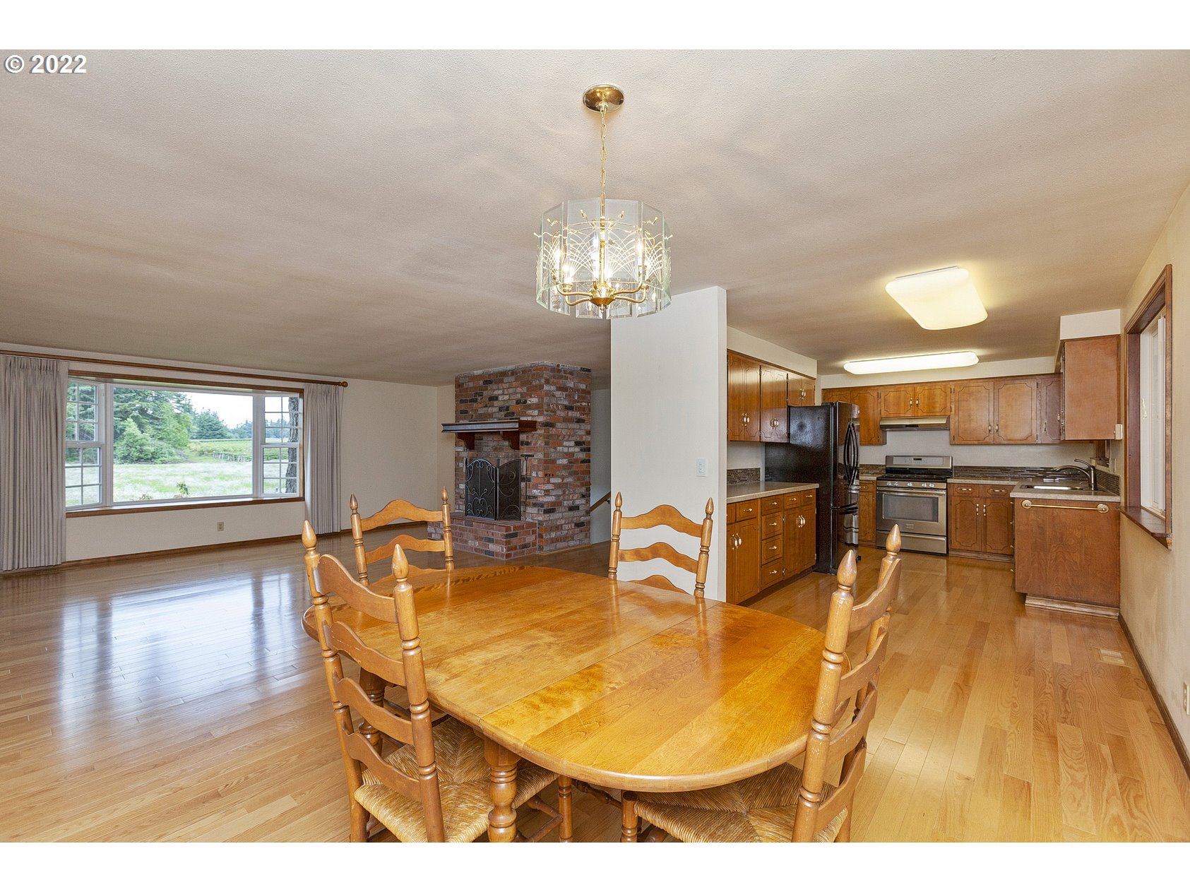 16190 South Wilson Road Oregon City, OR 97045 - Photo 10 of 32 a view of a dining room with furniture and wooden floor