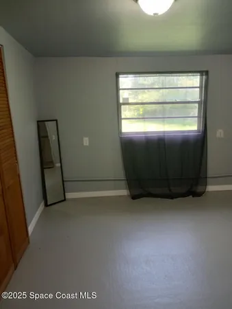 an empty room with wooden floor and closet