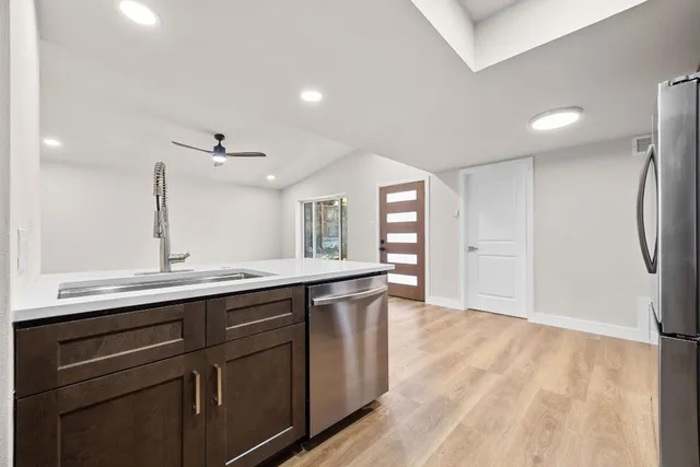 a kitchen with stainless steel appliances granite countertop wooden cabinets and a stove top oven