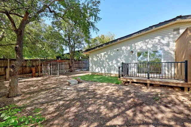 a view of deck with wooden fence and trees
