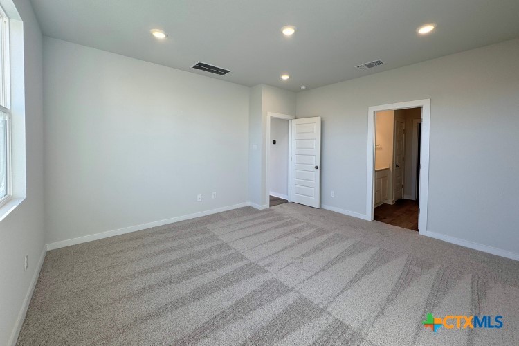 260 Escape Way Jarrell, TX 76537 - Photo 4 of 12 an empty room with cabinet and hallway view
