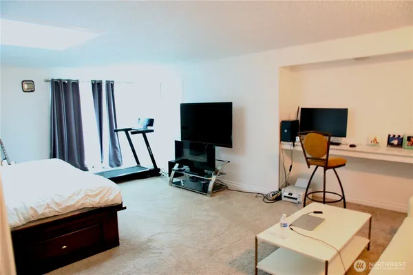 a bedroom with furniture and a flat screen tv