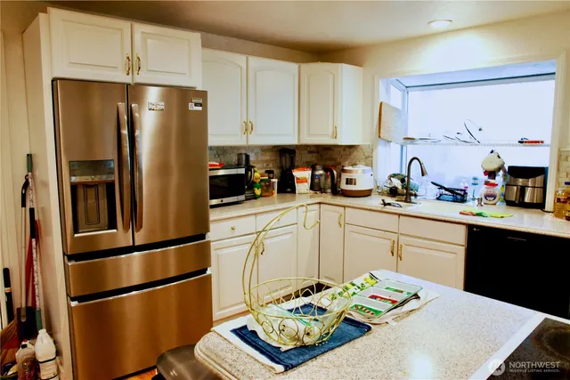 a kitchen with stainless steel appliances a refrigerator sink and cabinets