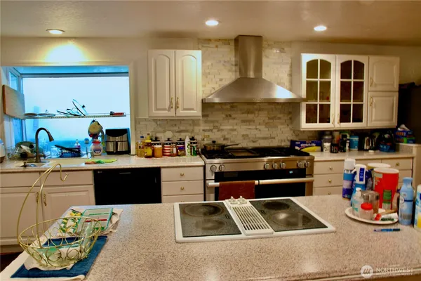 a kitchen with stainless steel appliances kitchen island granite countertop a sink and cabinets