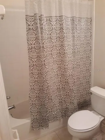 a white toilet sitting next to a shower curtain