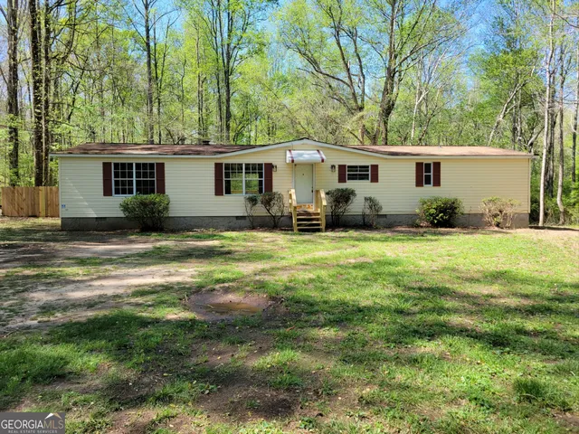 a view of a house with yard and sitting area