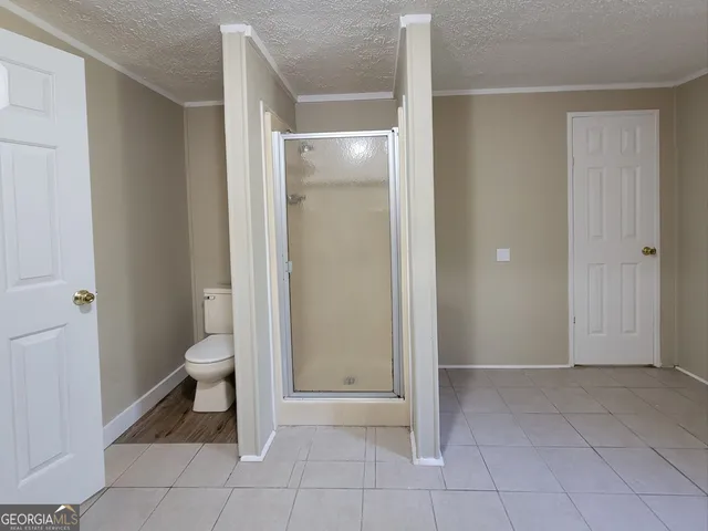 a bathroom with a toilet and a shower