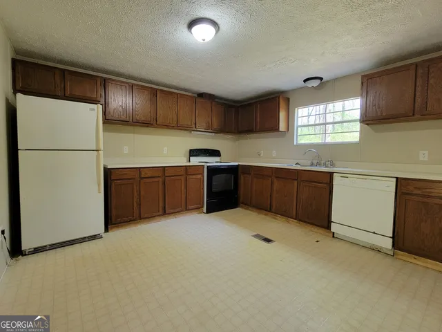 a kitchen with stainless steel appliances granite countertop a refrigerator a sink a stove a microwave and island