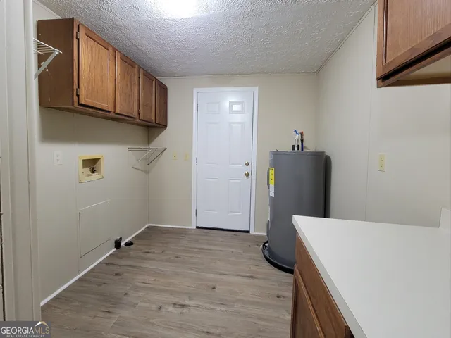 a view of a kitchen with fridge and wooden floor