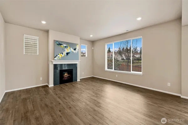 a view of an empty room with a window and fireplace