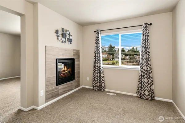 a view of an empty room with window and fire place