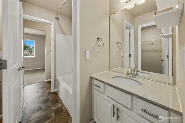 a bathroom with a granite countertop sink a mirror and a shower