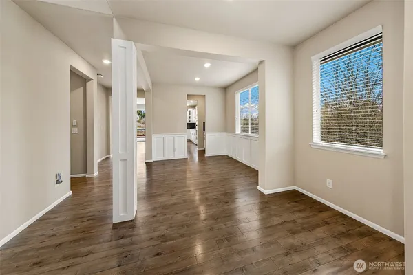 a view of empty room with wooden floor and window