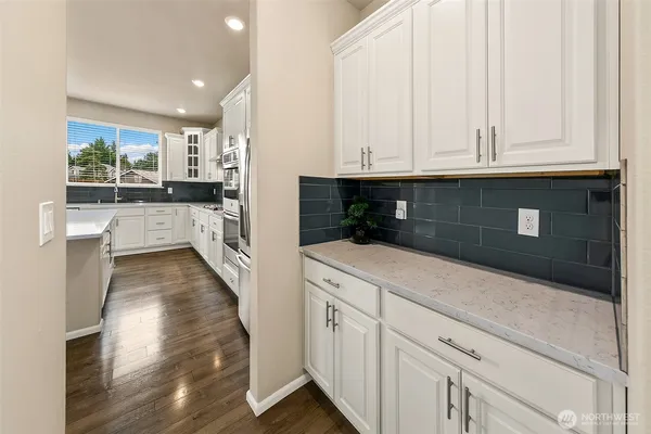 a kitchen with granite countertop white cabinets and stainless steel appliances