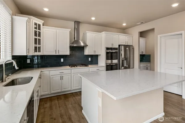 a kitchen with stainless steel appliances a refrigerator sink and microwave