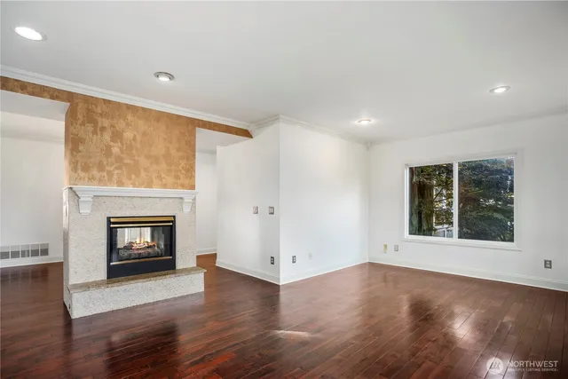 an empty room with wooden floor and fireplace