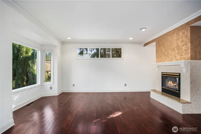 an empty room with wooden floor and a fireplace