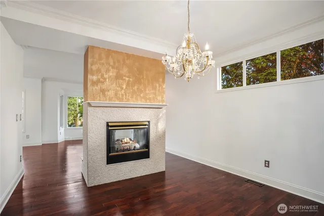 a living room with a fireplace and chandelier