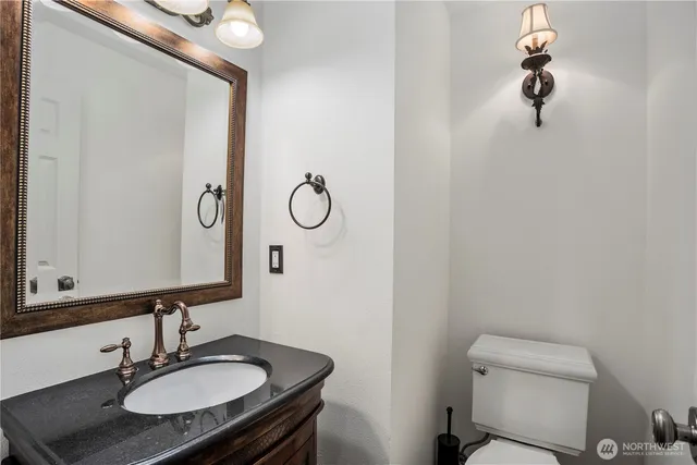 a bathroom with a sink a toilet and mirror