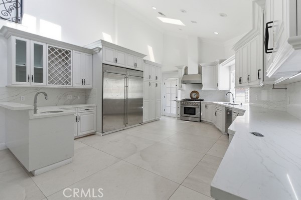 5048 Hesperia Avenue Encino, CA 91316 - Photo 4 of 30 a large white kitchen with cabinets a sink and stainless steel appliances