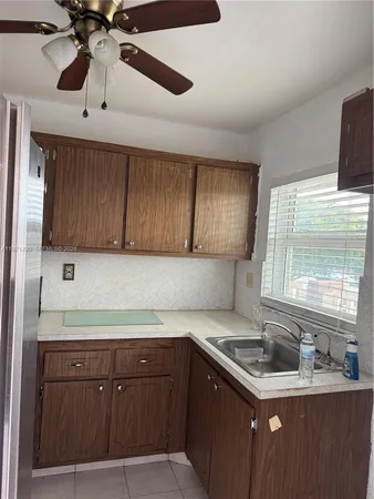 a kitchen with a sink cabinets and window