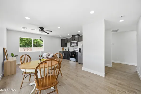 an empty room with wooden floor and ceiling fan