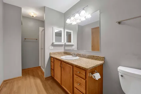 a bathroom with a granite countertop sink a toilet and a mirror