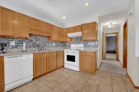 a kitchen with stainless steel appliances granite countertop a stove a sink and a refrigerator