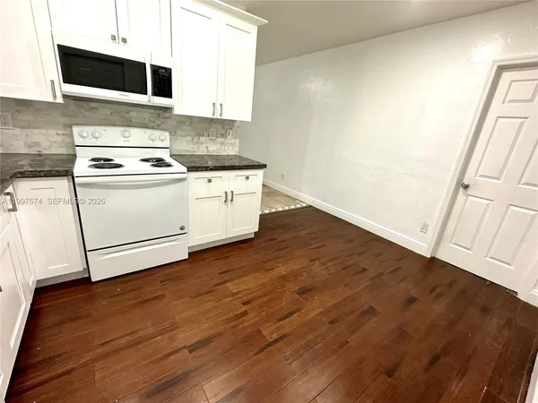 a kitchen with wooden floors and white appliances