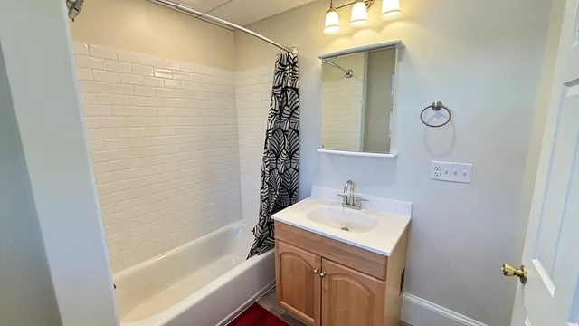 a bathroom with a sink a toilet a mirror and shower