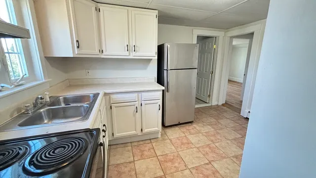 a view of a hallway with wooden floor and a bathroom
