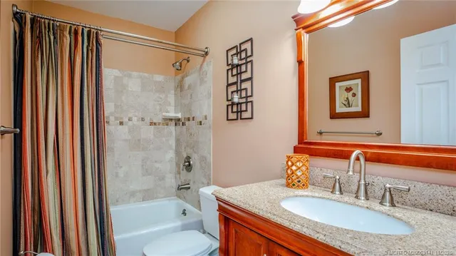 a bathroom with a granite countertop sink and a bathtub