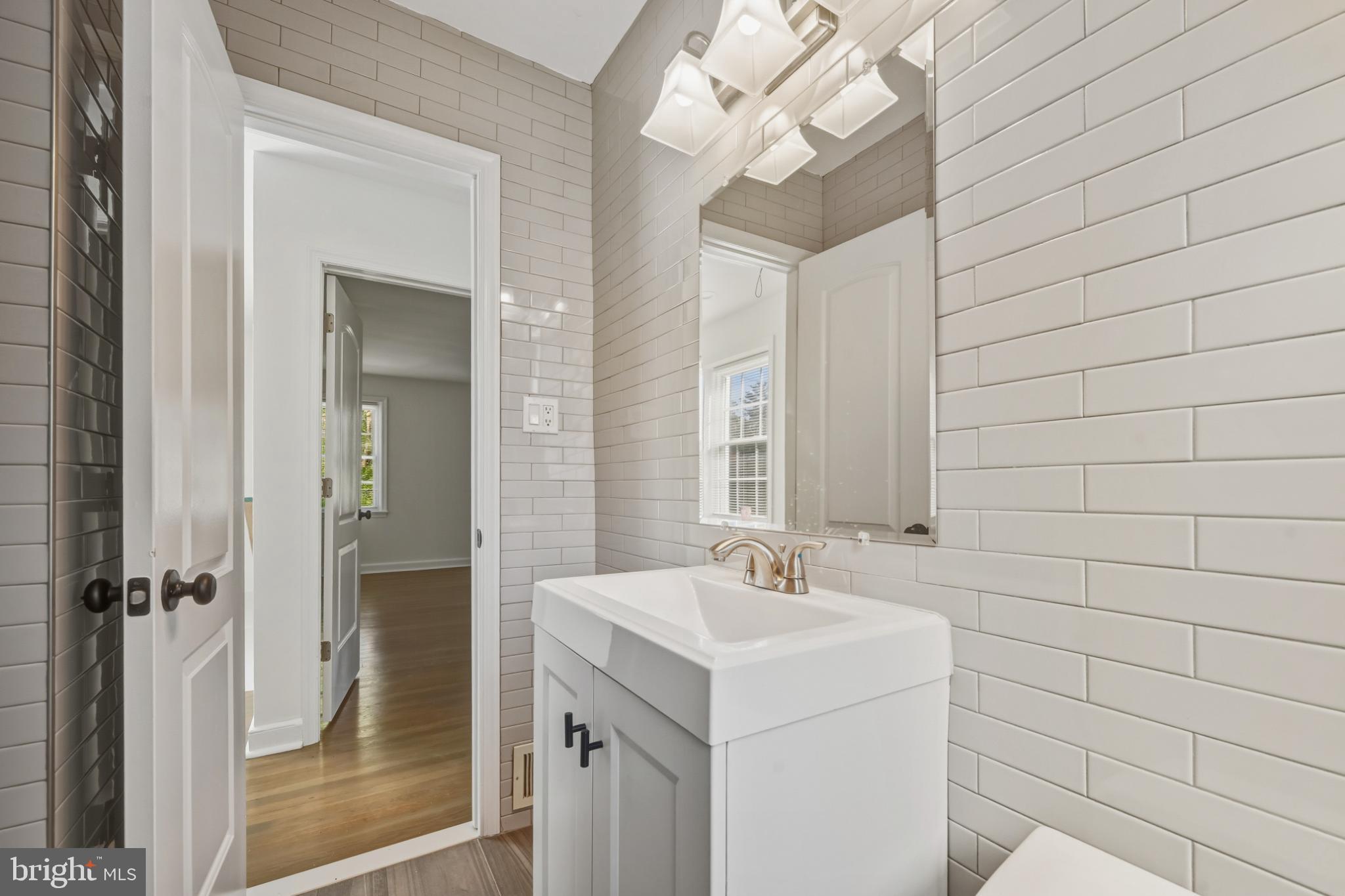2110 Suitland Terrace Southeast Washington, DC 20020 - Photo 9 of 16 a bathroom with a sink a mirror and a shower