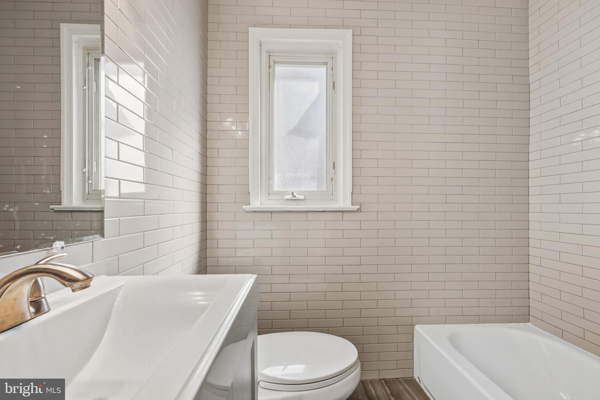 2110 Suitland Terrace Southeast Washington, DC 20020 - Photo 10 of 16 a bathroom with a sink a toilet and bathtub