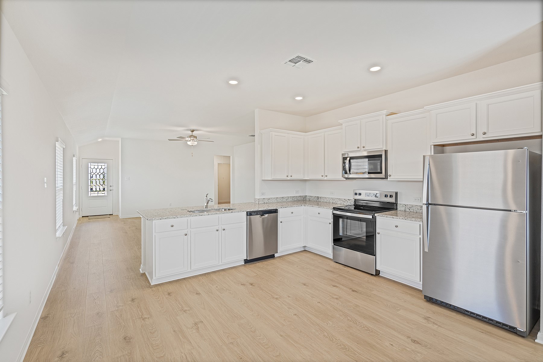 14713 Wahlbergs Way Elgin, TX 78621 - Photo 4 of 10 Upgrades include spacious granite countertops, brand-new stainless steel appliances and modern white cabinets. You are sure to love this chef-ready kitchen!