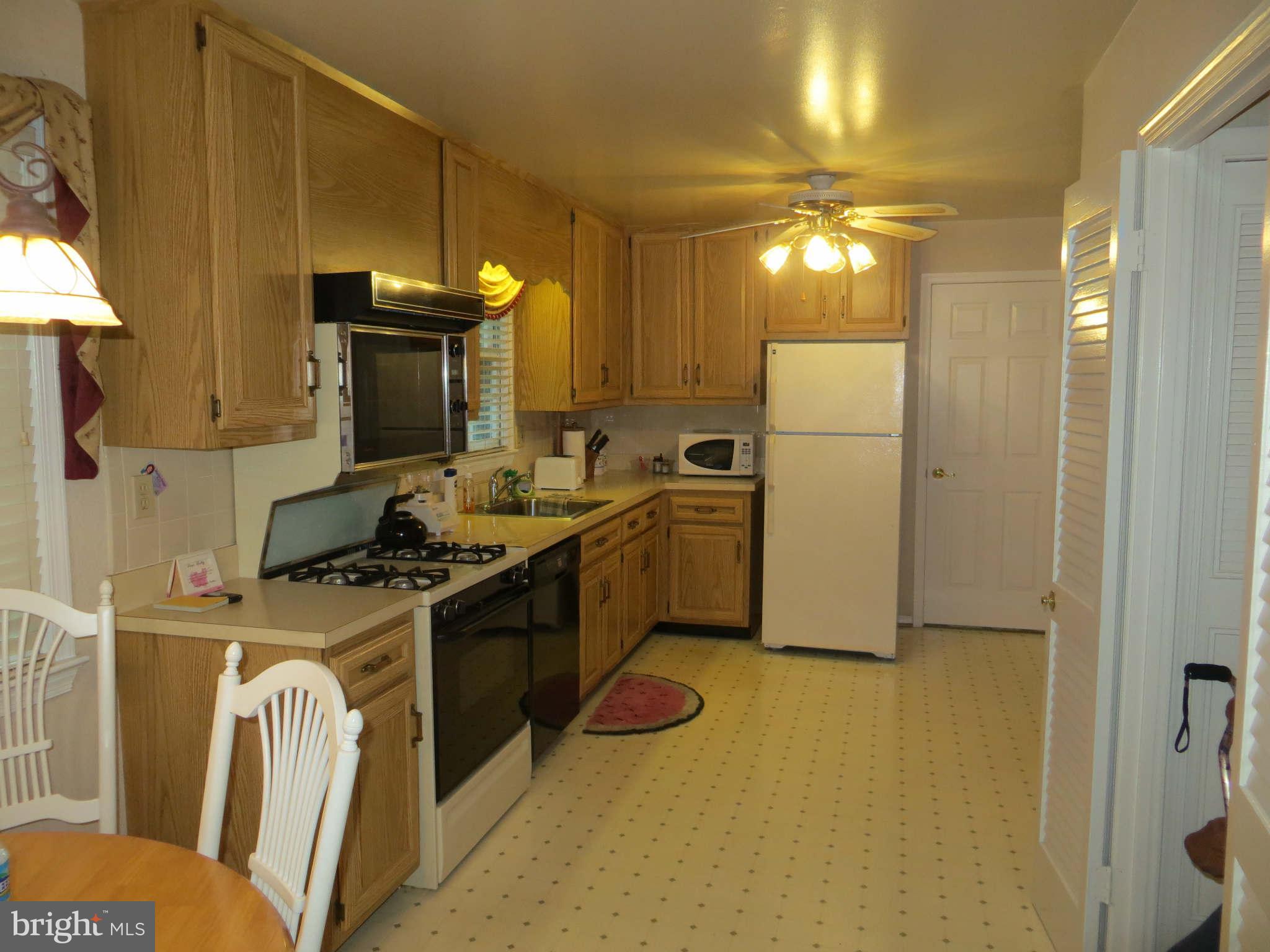 12504 Kuhl Road Silver Spring, MD 20902 - Photo 8 of 27 a kitchen with stainless steel appliances granite countertop a stove a refrigerator and a microwave