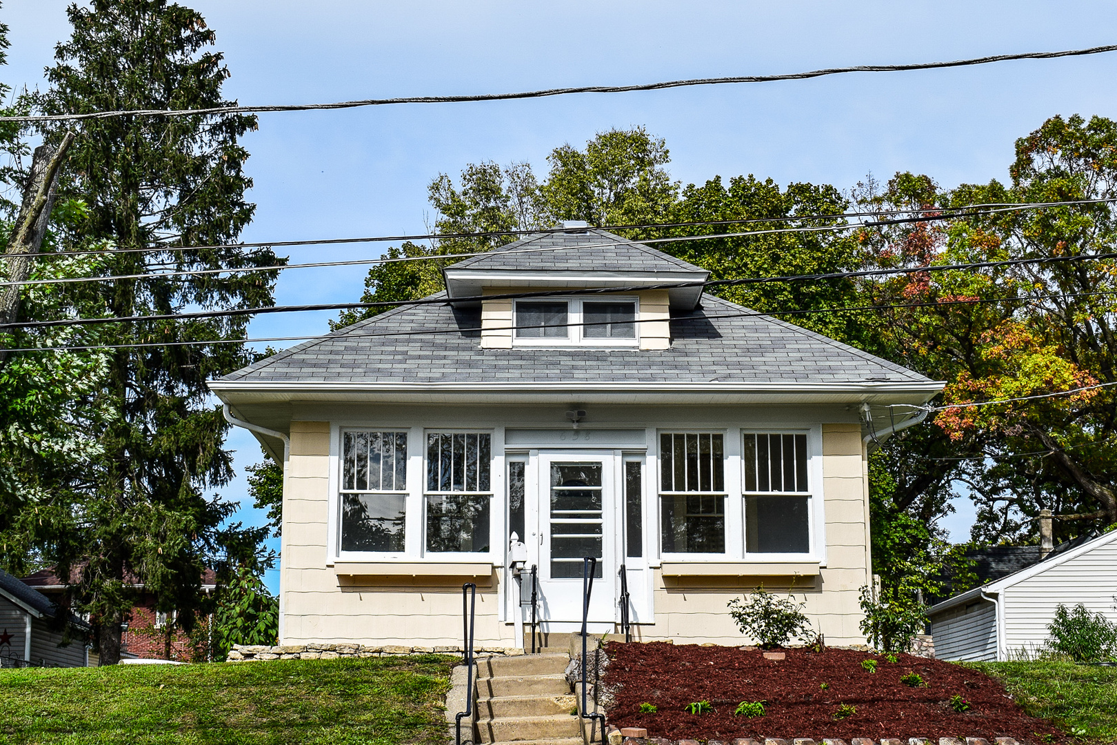 a front view of a house with a garden