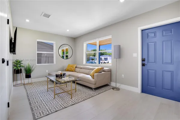 a living room with furniture and wooden floor