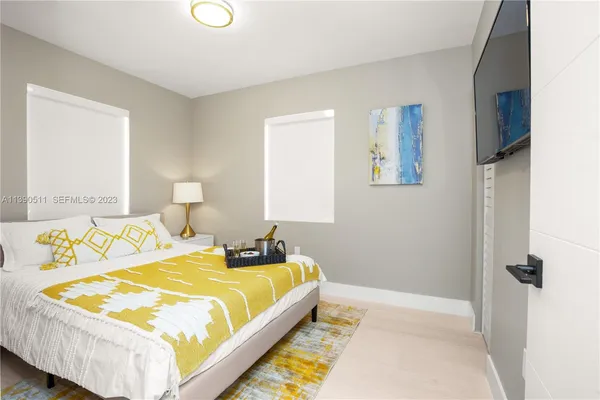 a bedroom with a bed and a lamp on dresser