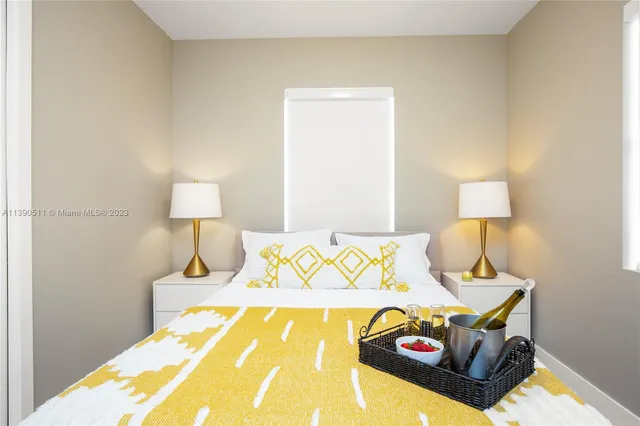 a bedroom with a bed and a lamp on dresser