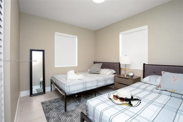 a bedroom with two beds and painting on the wall