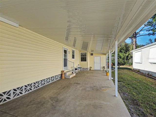 a backyard of a house with table and chairs