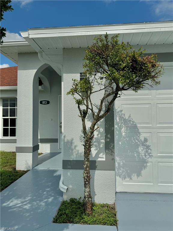 813 Naples Avenue South Lehigh Acres, FL 33974 - Photo 1 of 13 a front view of a house with garden