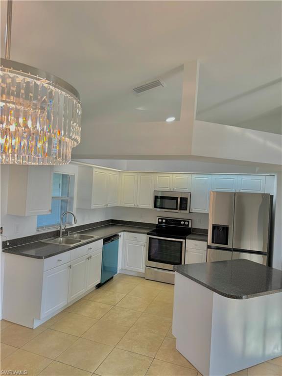 813 Naples Avenue South Lehigh Acres, FL 33974 - Photo 7 of 13 a large kitchen with granite countertop a sink and stainless steel appliances