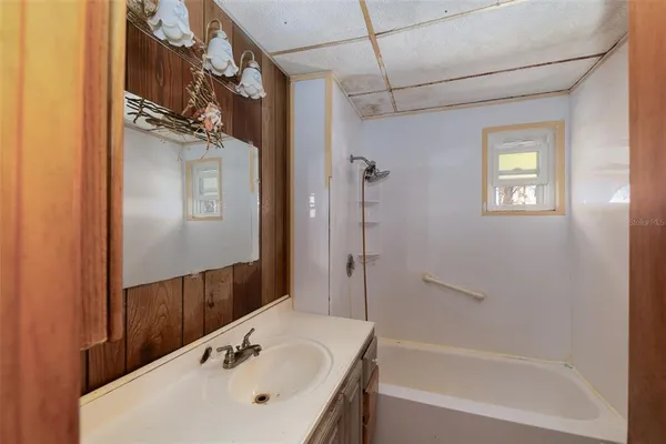 a bathroom with a sink a mirror and a bathtub
