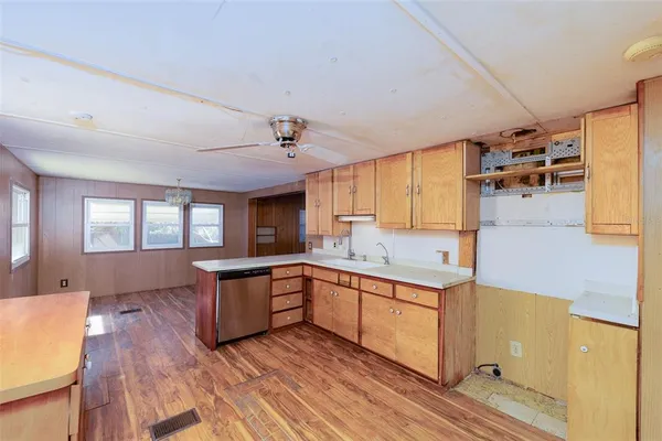 a large kitchen with a wooden floor and cabinets