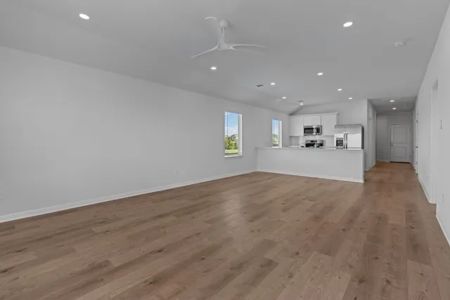 a view of an empty room with wooden floor