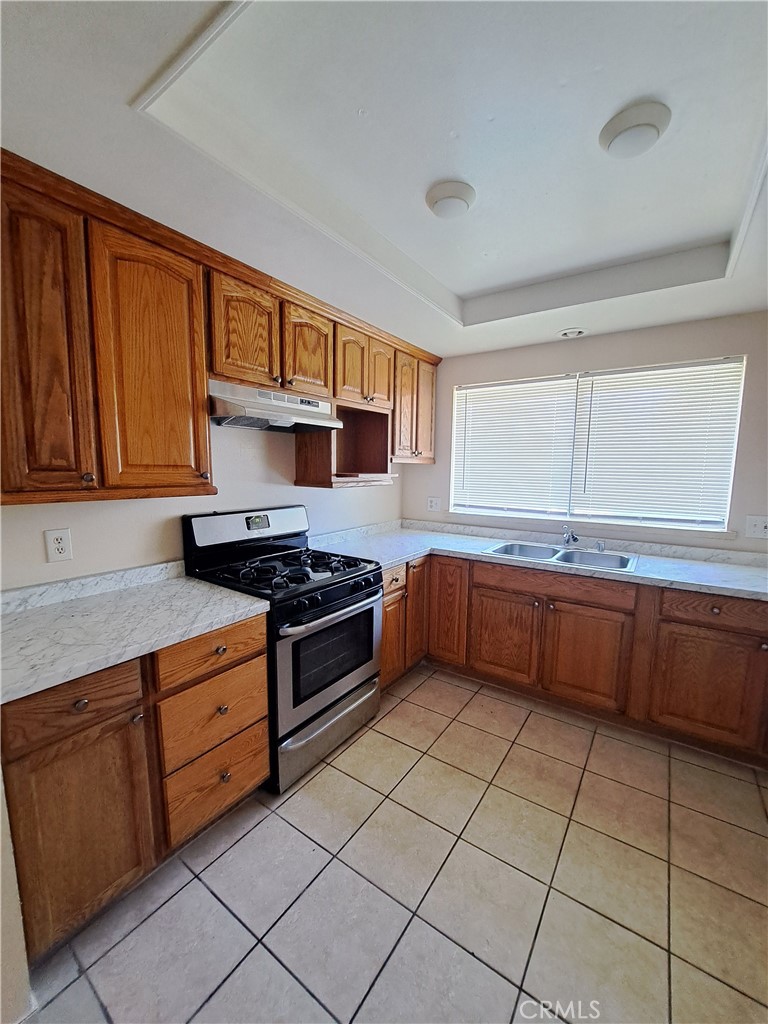 12760 Perris Boulevard, Unit A1 Moreno Valley, CA 92553 - Photo 3 of 12 a kitchen with stainless steel appliances granite countertop a stove a sink and a refrigerator