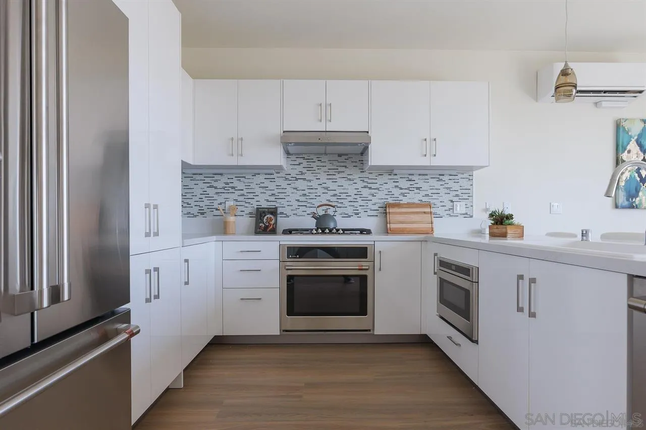 8292 High Street La Mesa, CA 91941 - Photo 5 of 23 a kitchen with white cabinets stainless steel appliances and sink